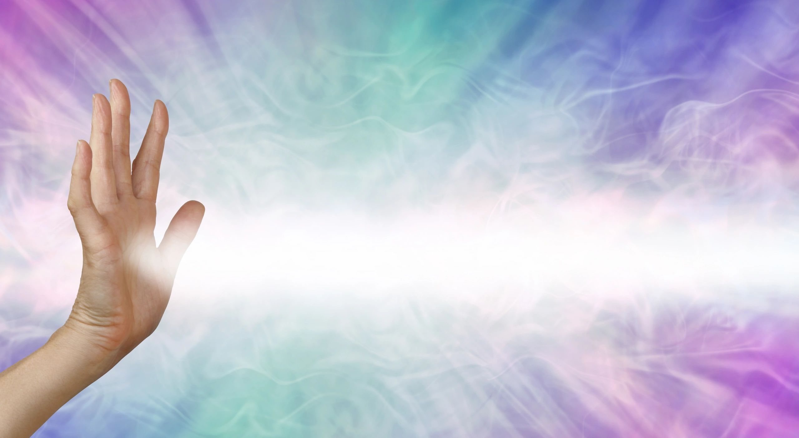 Hands raised in prayer with light