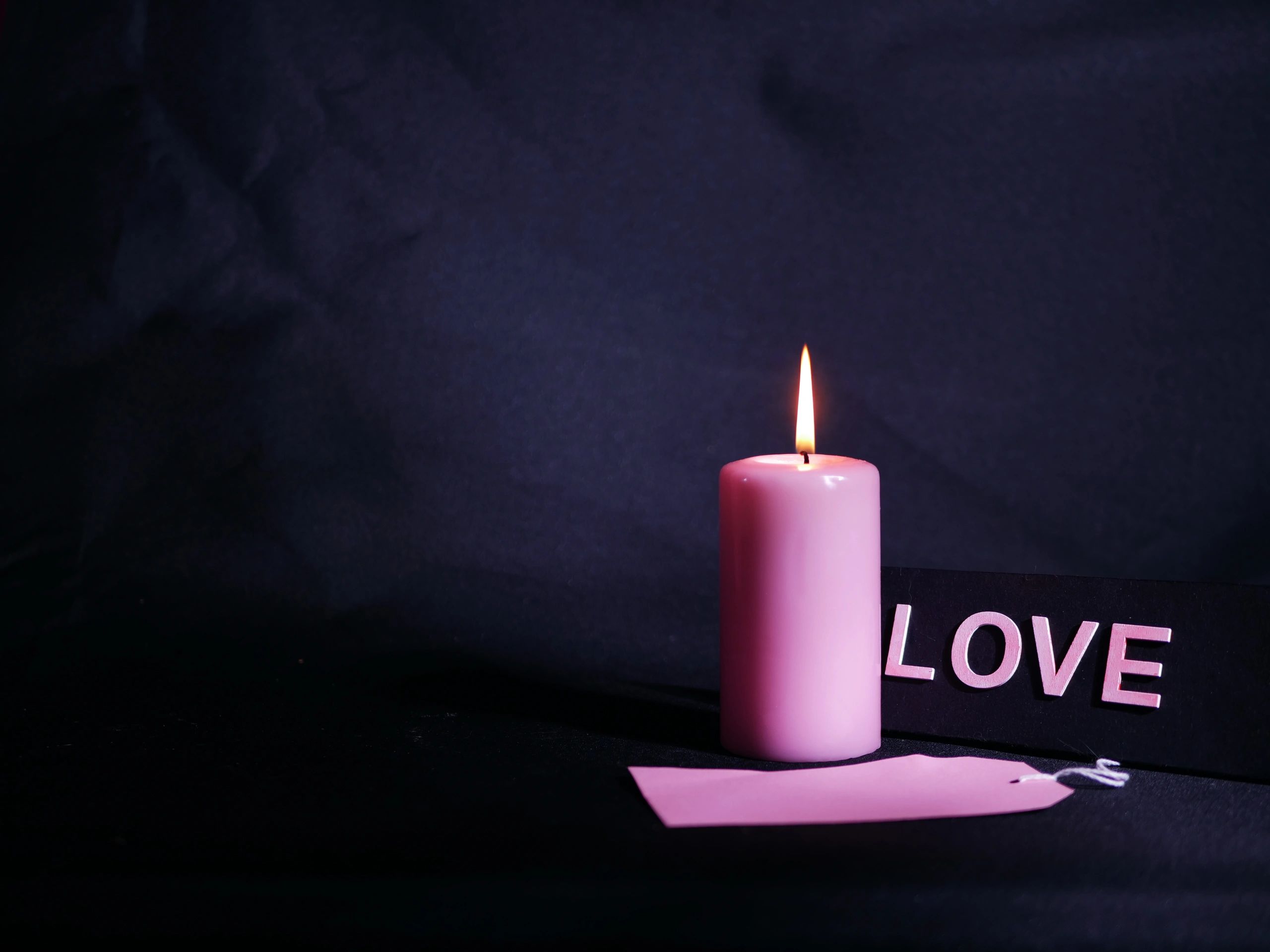 Warm candlelight in darkness creating a peaceful prayer atmosphere