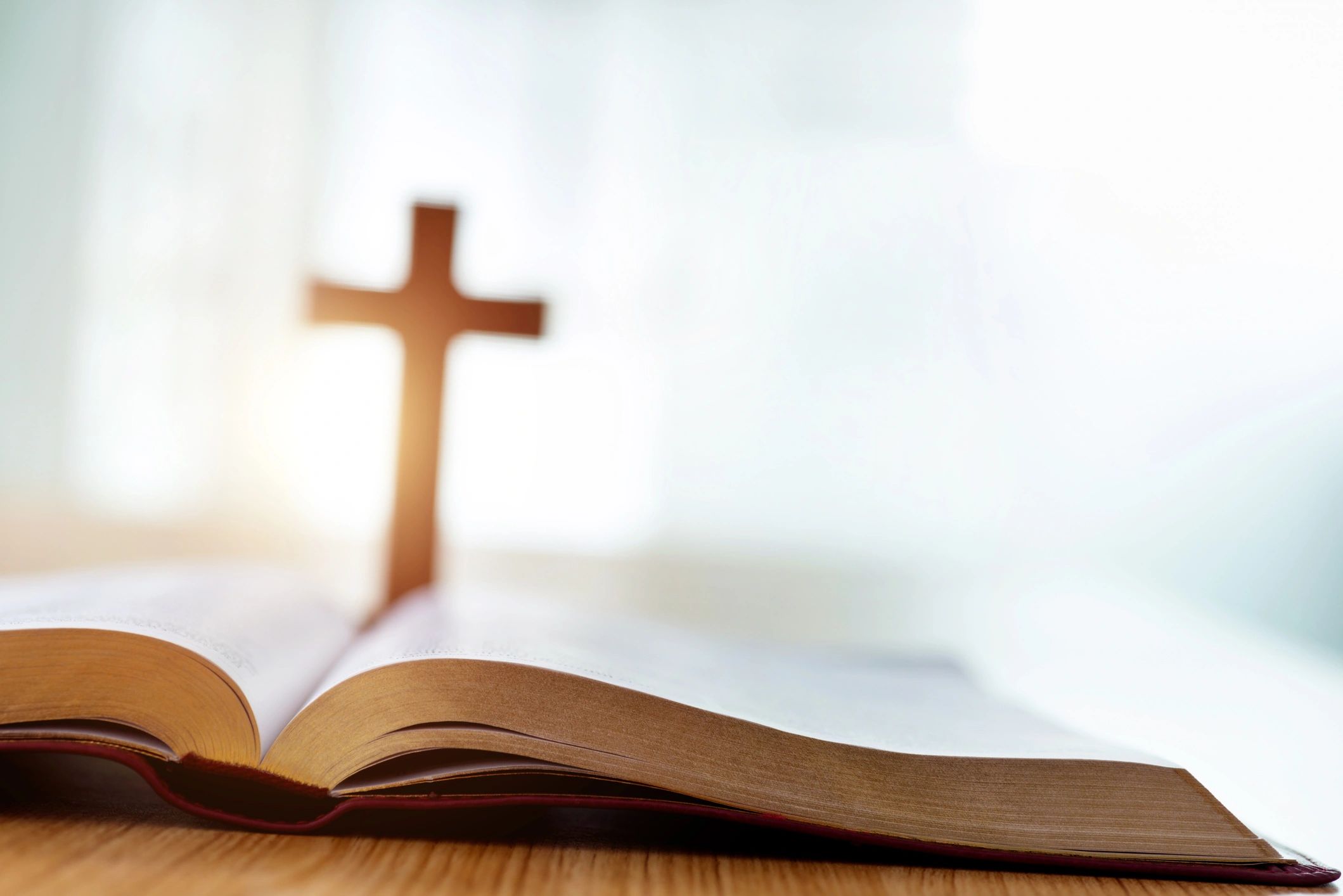 Bible and cross on a wooden desk