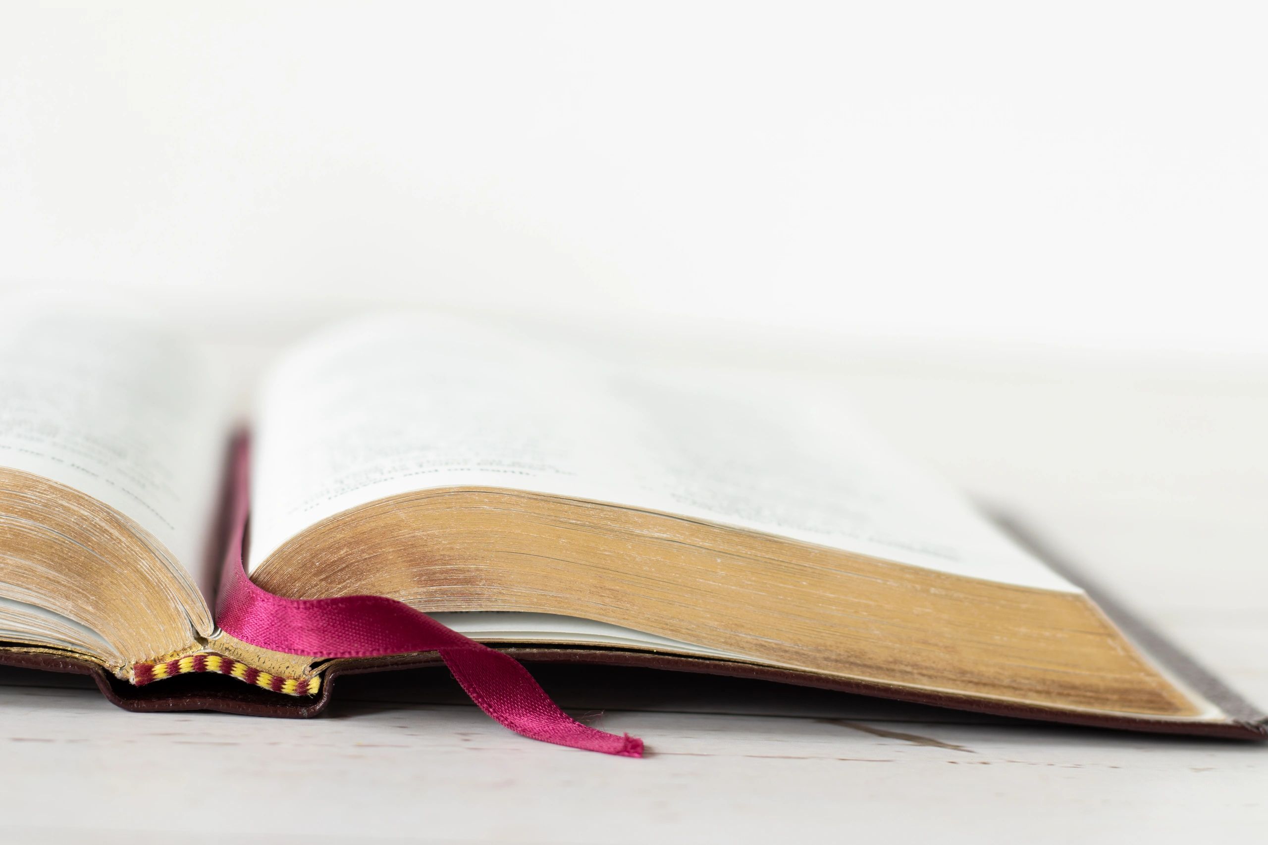 Open Bible with gold-edged pages on wooden table