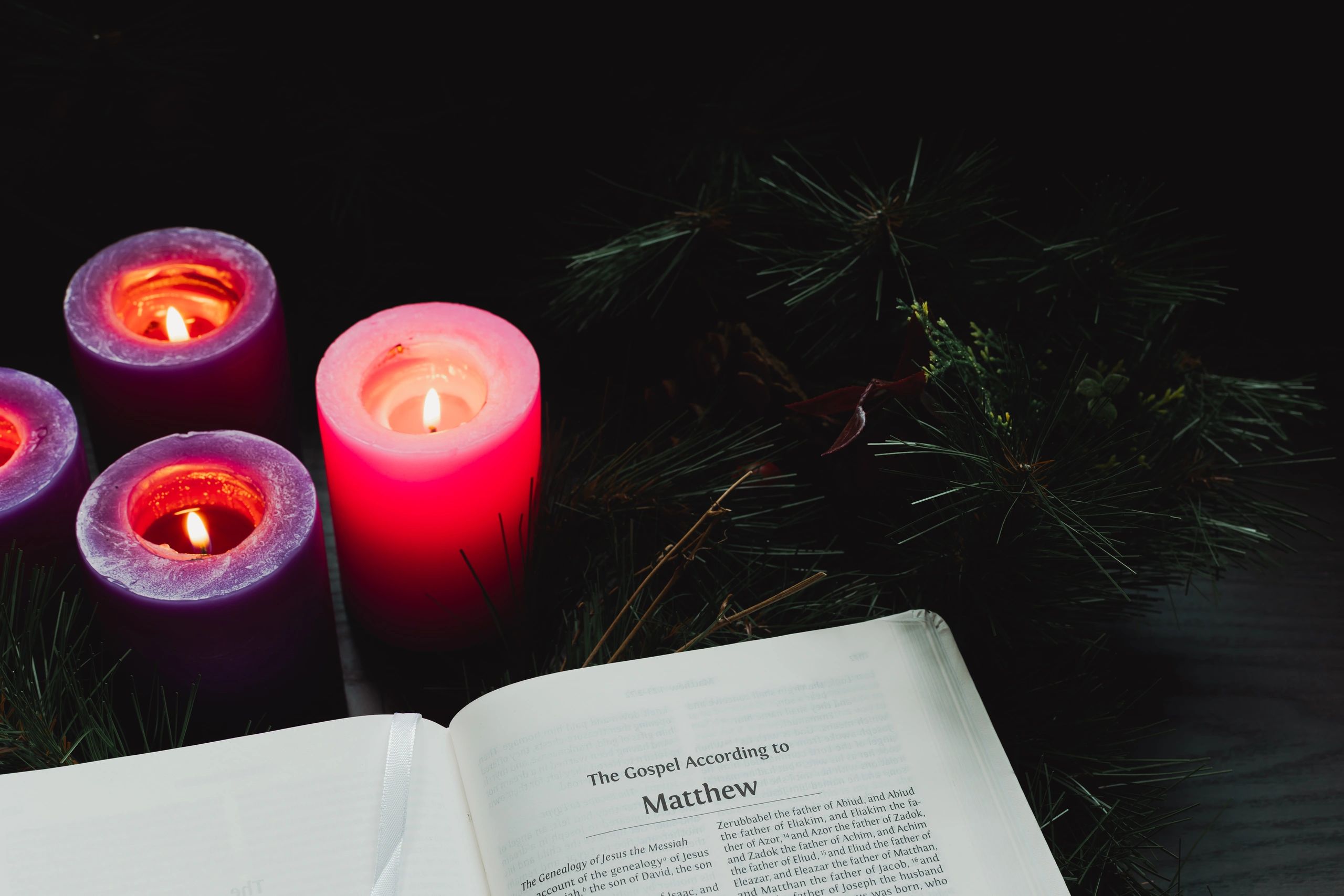 Open Bible with lit candles in a quiet room