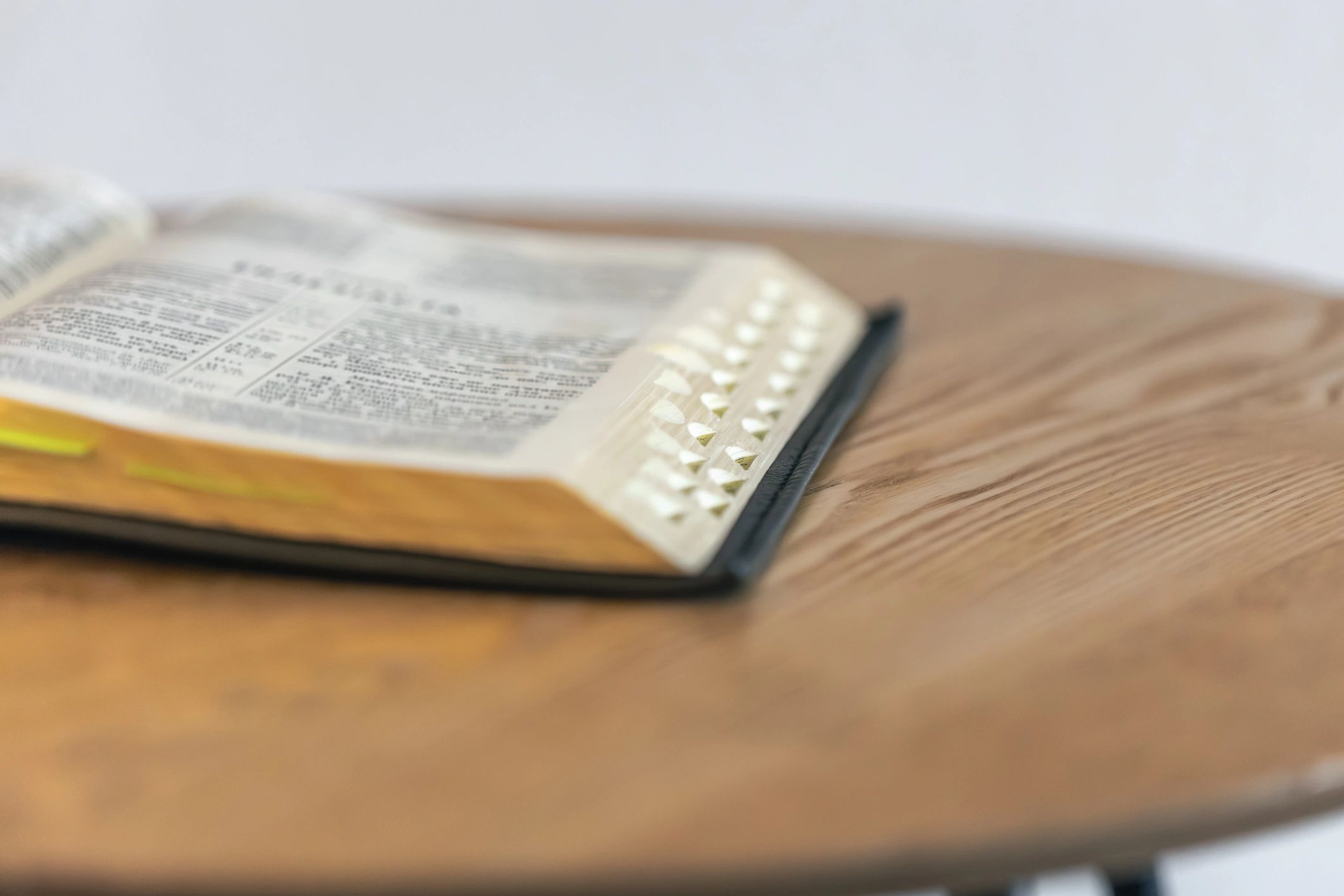 Open Bible with index tabs on wood. Calm reading.