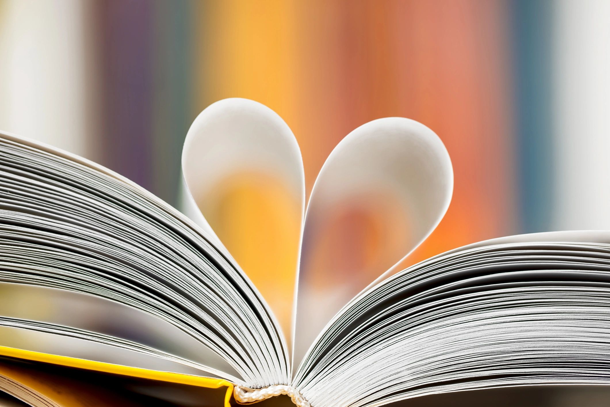 Love reading concept - open book with pages folded into a heart shape